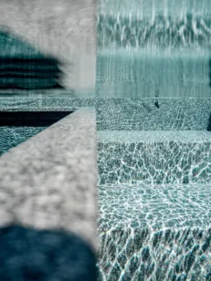 Unterwasserbild einer Treppe in einem Schwimmbecken aus massiven Naturstein