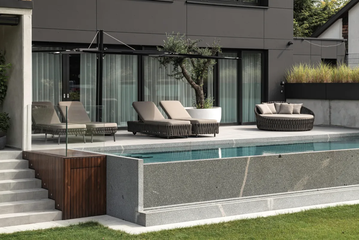 Infinitybecken mit Terrasse und Liegeloungen