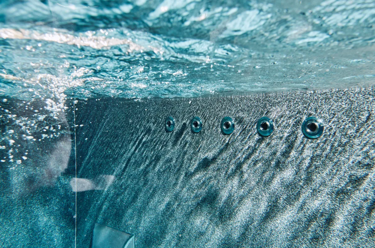 Unterwasserbild von Massagedüsen in einem Becken aus massiven Naturstein