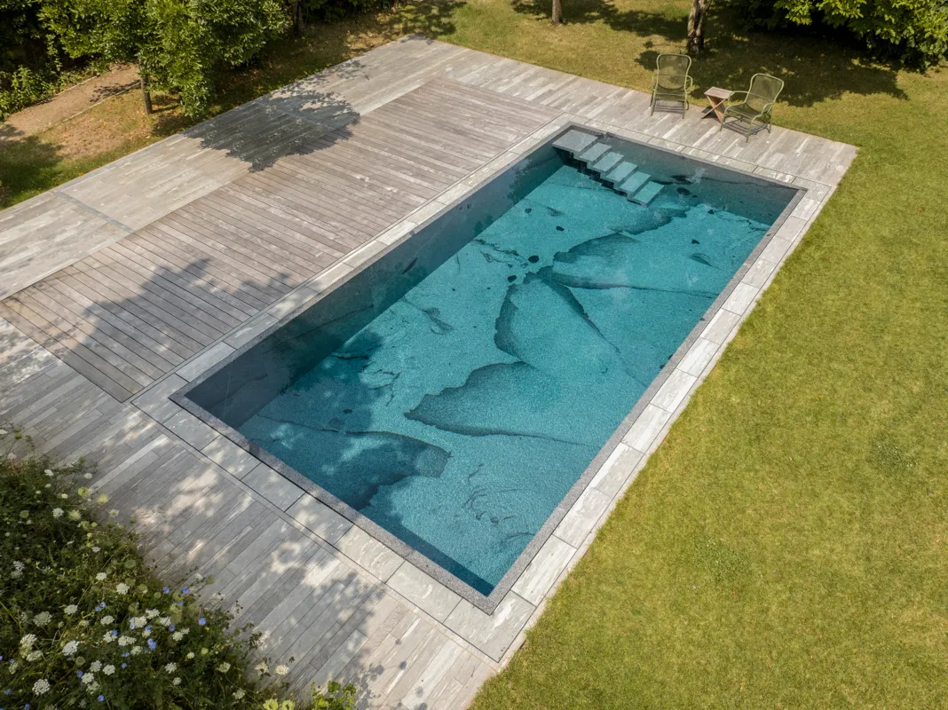 Vogelperspektive eines Natursteinpools mit großflächiger Masserung