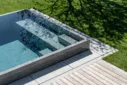 Natursteinpool mit Blockstufentreppe und integrierter Rolladenabdeckung