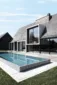 Schwimmbecken gefertigt aus massivem Granit vor einem architektonisch schönem Haus