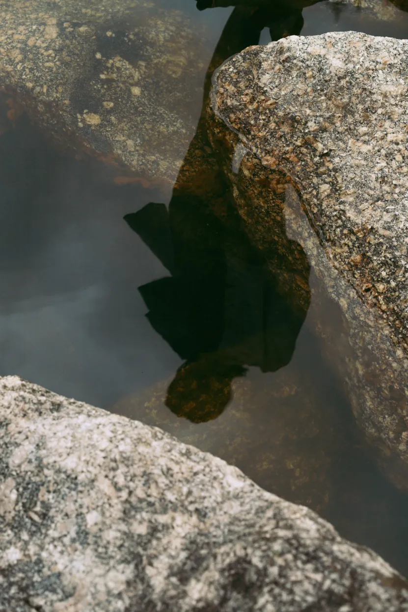Ein Schatten einer Frau spiegelt sich in der Wasseroberfläche